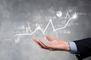 Businessman in hand hold banking business finance graph and invest in stock market investment point,economic growth and investor concept.analysis virtual stock market chart,analyze by use technology