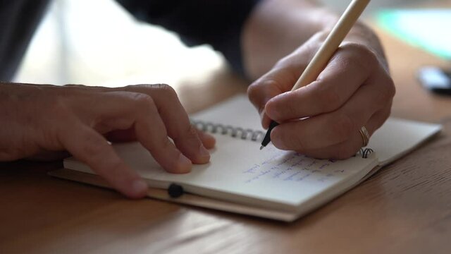 Homme qui &eacute;crit sur un carnet.