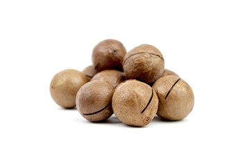 Roasted macadamia nuts isolated on white background. Heap of unshelled macadamia nuts