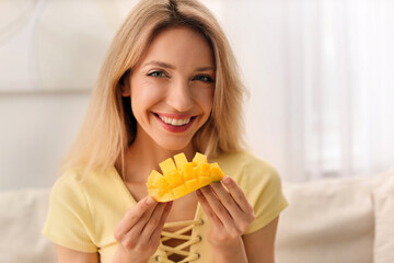 Young woman with fresh mango at home. Exotic fruit