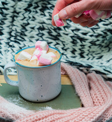 Man decorating hot chocolate with marshmallow. Winter mood