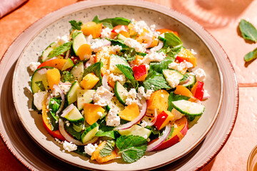 Summer peach and cheese salad on tile table, top view
