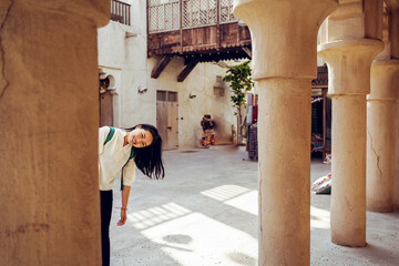 Cheerful woman standing in yard of old stone house