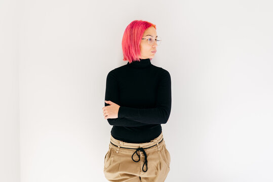 Trendy woman with pink hair looking away