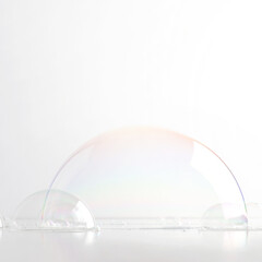 A hemisphere of a transparent soap bubble mockup for the presentation of cosmetics. White clean...