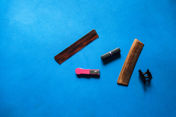 Grooming accessory items nail clipper, comb, hair clip and lipstick on a background with use of selective focus 