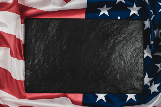Black stone plaque on the American flag with place for text.