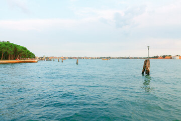 Fototapeta premium Venice water canal with old wooden berth . Water surface of lagoon in Venezia