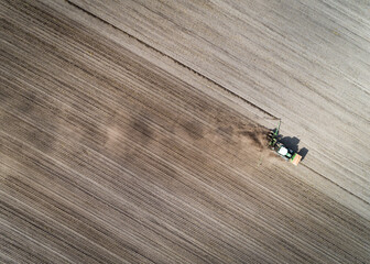 Luftaufnahme eines Schleppers mit Maislegegerät im Einsatz. Ende April bis Anfang Mai wird der...