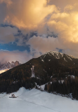 Clouds over snowy mountain. Santa Maddalena church.