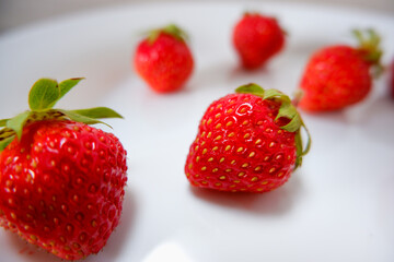 Fresh berries. Fresh juicy red strawberry on a white plate. Close-up photo. Vitamin charge.