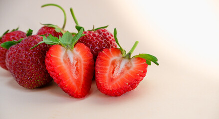 Fresh berries. Fresh juicy red strawberries on a pastel pink background with shadows. Close-up photo.