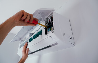 Repair and maintenance of the air conditioner. A technician repairs an air conditioner. Close-up...