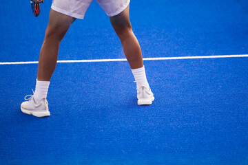 Crop men playing tennis on court