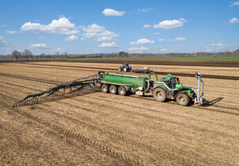 Fototapeta premium Modernste Landwirtschaftsmaschinen, um die Gülle bodennah und effizienz auf das Feld zu bringen. Drohnenfoto