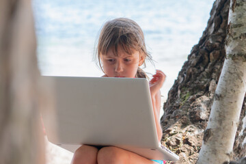 Conceptual image: work and rest at the same time. Happy young beautiful business girl can work remotely and relaxing on a beautiful sea beach. Horizontal image.