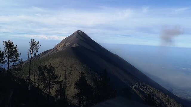 Landscape panorama view of Volcan de Fuego in Guatemala during eruption with smoke and dust in the air. Active stratovolcano of Acatenango constantly active spewing lava, rock and ash.