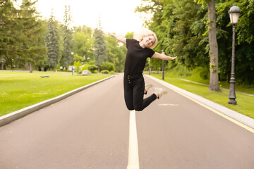 Attractive young woman walks along the line of the road enjoying nature.