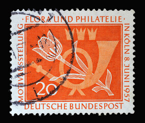 Stamp printed in Germany, shows a post horn and a tulip. The occasion is the motif exhibition flora...