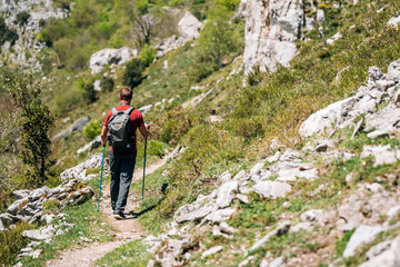 Fototapeta na wymiar Traveler with backpack trekking on cliff