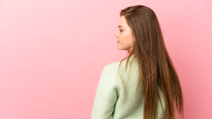 Teenager girl over isolated pink background in back position and looking side