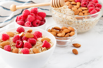 Healthy breakfast. Bowl with oatmeal with fresh raspberries and almonds