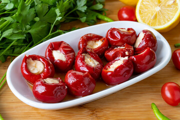 Cheese filled cherry peppers on wooden background. Local name peynir dolgulu kiraz biberi