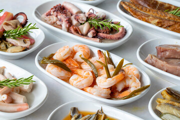 Set of Seafood Dishes. Seafood on a plate. On a white wooden background. Selective focus Shrimp. Prawns, lakerda, octopus salad, mussels with marinade