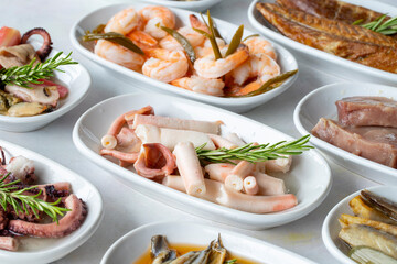 Set of Seafood Dishes. Seafood on a plate. On a white wooden background. Selective focus octopus salad. Lakerda, octopus salad, shrimp, fish salad