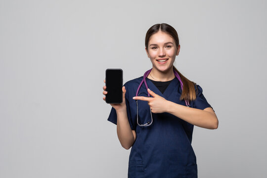 Beautiful female doctor showing a smart phone screen on a white background