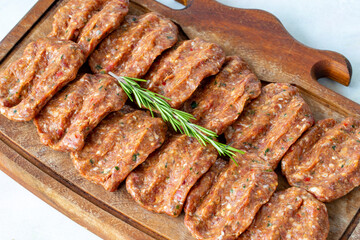 Spicy raw meatballs on wooden background. Turkish meatballs