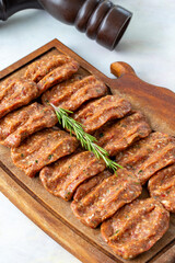 Spicy raw meatballs on wooden background. Turkish meatballs