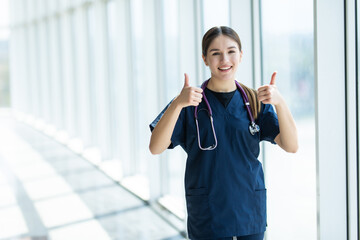 Young female doctor gesturing with thumbs up