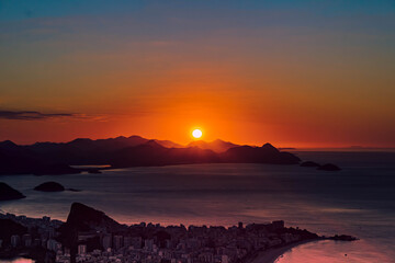 Early morning sunrise over the sea. some clouds city mountains