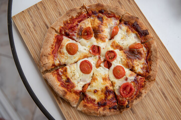 Delicious margherita pizza with cherry tomatoes cut into slices