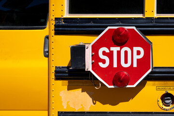 Red STOP sign on a yellow school bus - Powered by Adobe