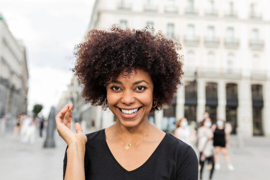 Smiling black woman on urban pavement in daytime