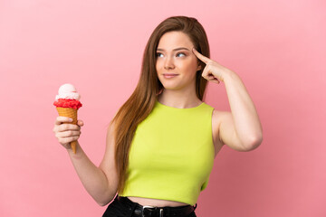 Teenager girl with a cornet ice cream over isolated pink background having doubts and thinking