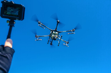 Agricultural drone in flight on a background of blue sky. Field spraying new technologies