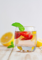 glass with a refreshing drink made from strawberries, lemon and mint. fresh summer cocktail close-up