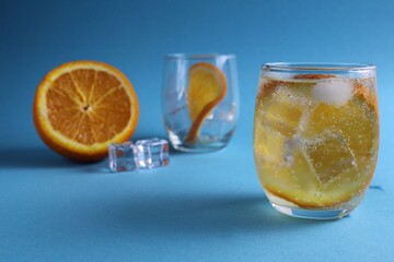 Step-by-step instruction cooking lemonade. Step 3. Ready drink with water orange and ice. Lemonade orange on a blue background. Summer drink