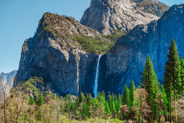 A gorgeous view of a waterfall in the mountains in Yosemite National Park, California.