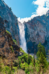 A gorgeous view of a waterfall in the mountains in Yosemite National Park, California.