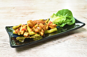 spicy fried squid with chili and lemon leaf couple lettuce on plate