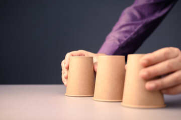 Closeup man going to take turn the cups in a shell game, three thimbles guessing game, concept for...