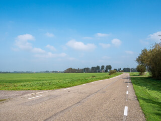 Polder landscape with empty road near Boornzwaag in Friesland, Netherlands