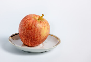red apple on a white saucer