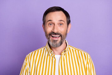 Photo of impressed handsome age bearded gentleman wear yellow shirt smiling isolated purple color background