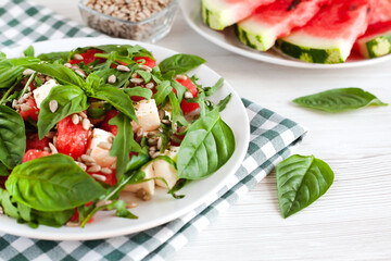 Fresh summer salad with watermelon, feta cheese, basil and peeled sunflower seeds. Healthy food concept. Close-up.