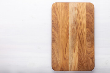 Rectangular cutting board on a white wooden table. Food preparation tool and kitchen utensils.
